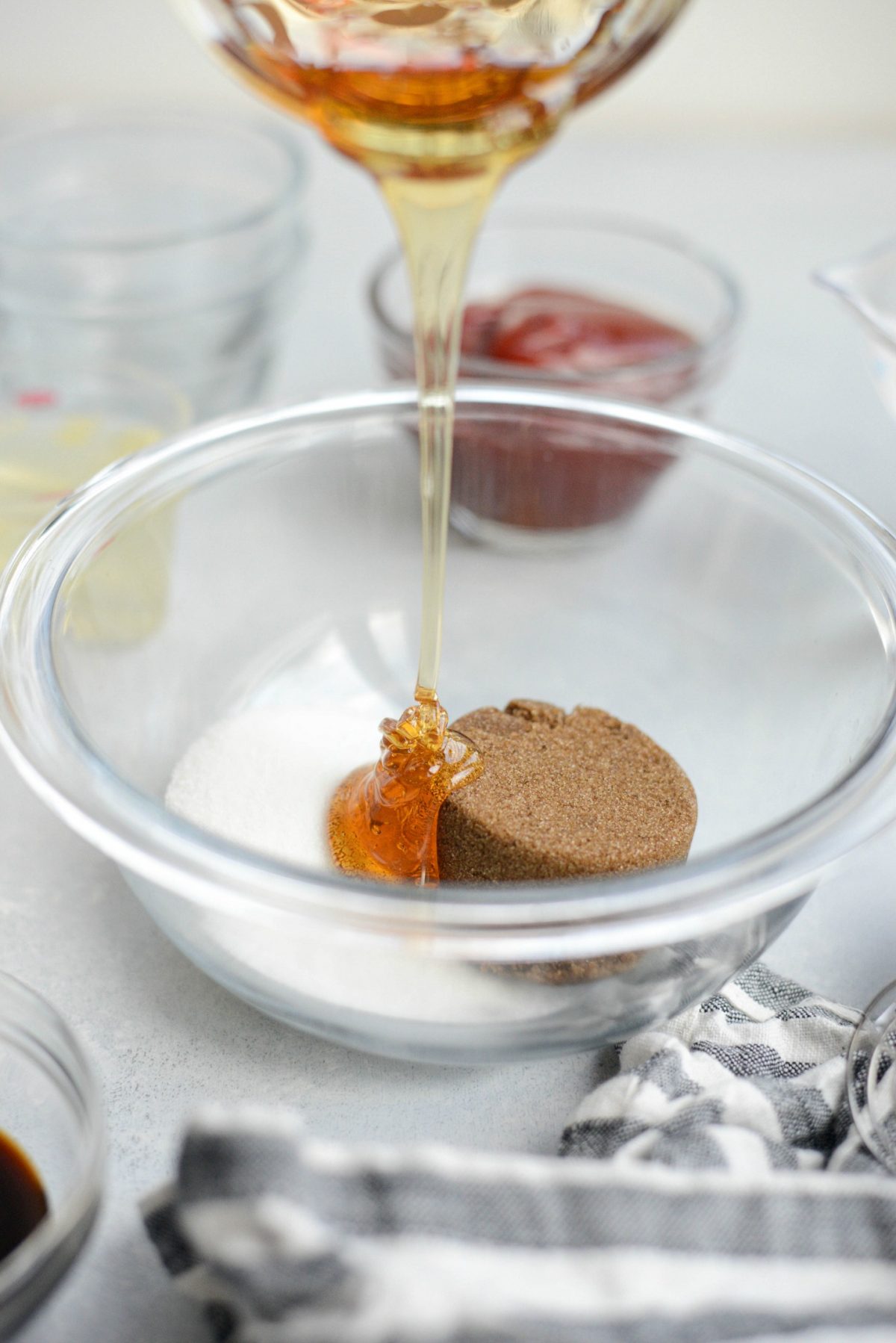 pouring honey into bowl of granulated and dark brown sugar