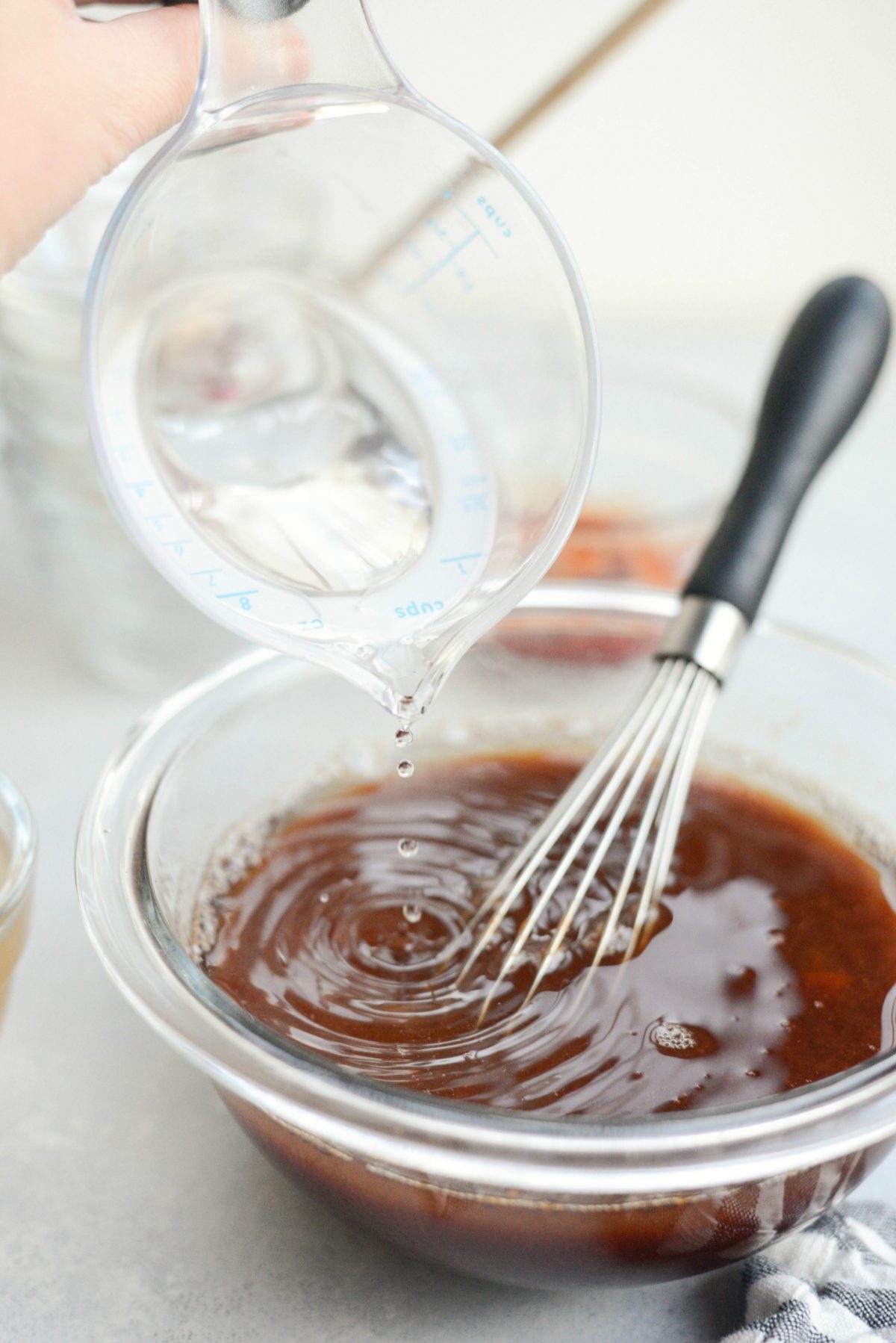 pouring vinegar into sweet and sour sauce