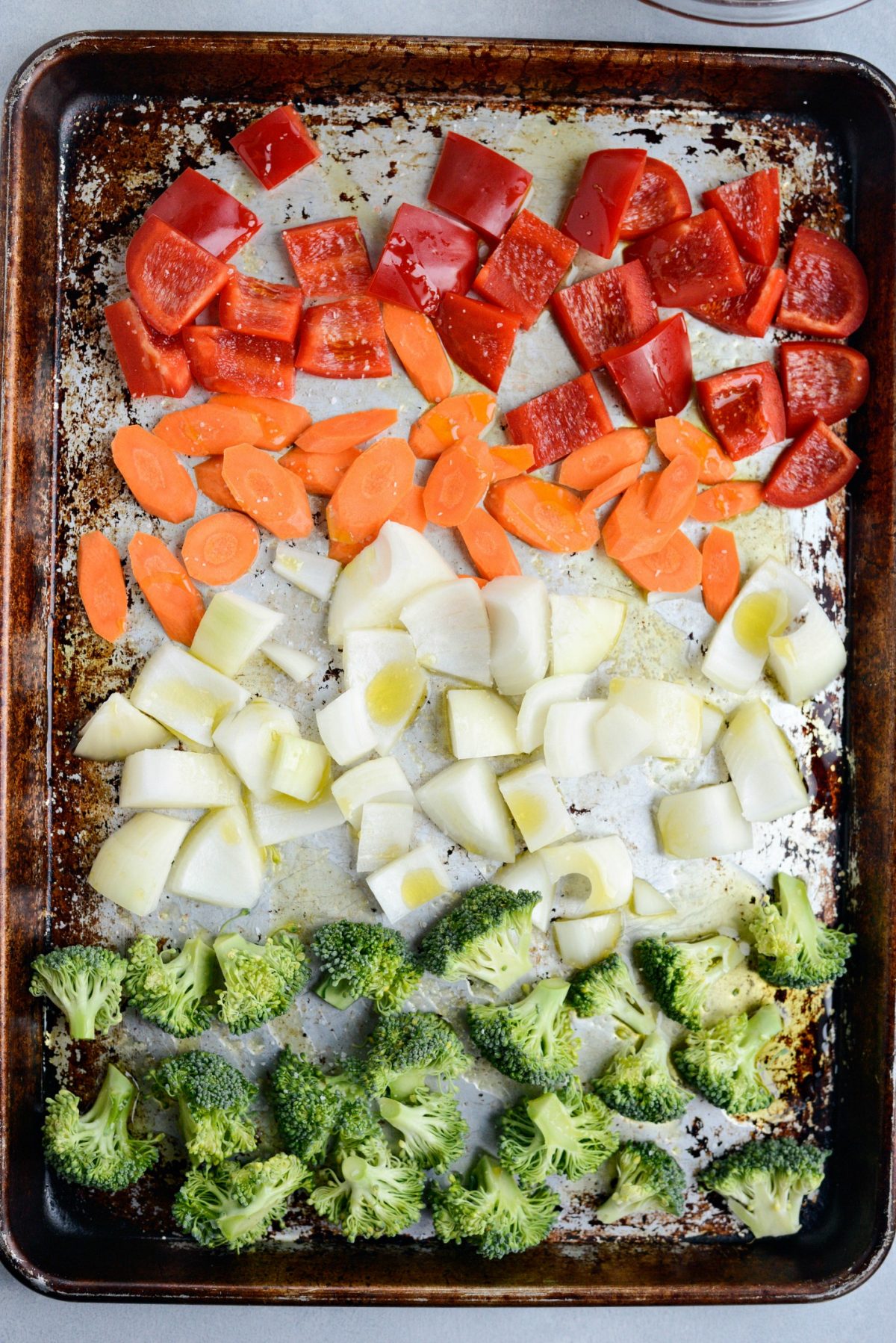 chopped red bell pepper, slice carrots, chopped onions and broccoli florets with olive oil and kosher salt on a rimmed sheet pan