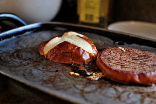 Griddled Steak Burgers with Jarlsberg + Sautéed Onions toasting pretzel buns