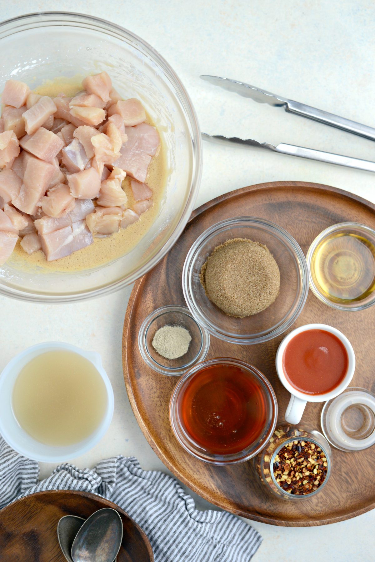 top down shot of chicken, egg whites, broth, sugar, white pepper, cider vinegar, hot sauce and chili flakes.