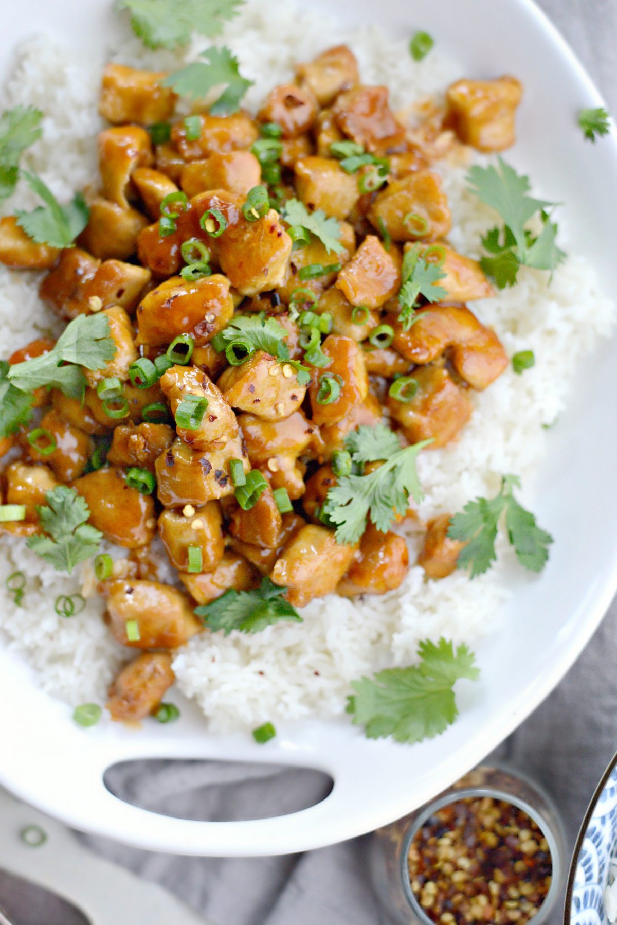 close up of firecracker chicken with rice in white bowl