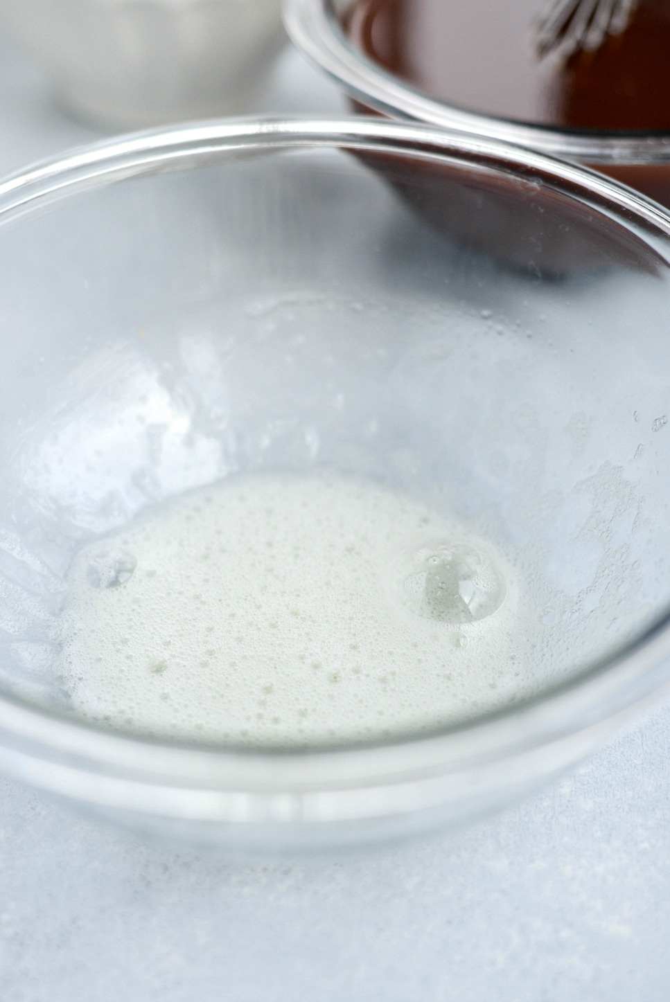 glass bowl of frothy whipped egg whites.