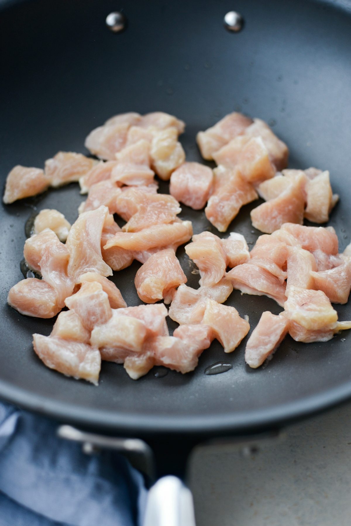 coated chicken searing in how wok with peanut oil