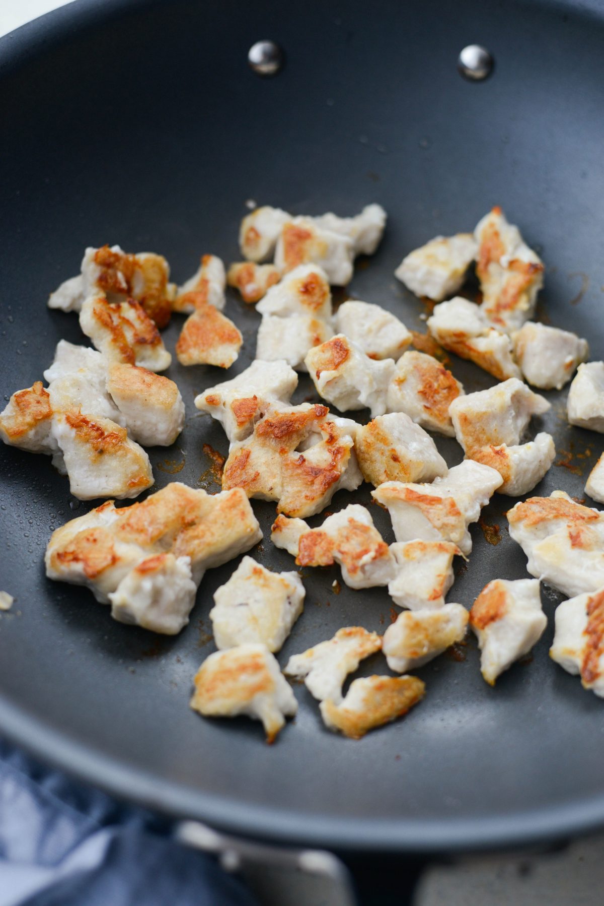 crispy browned pieces of chicken in wok.