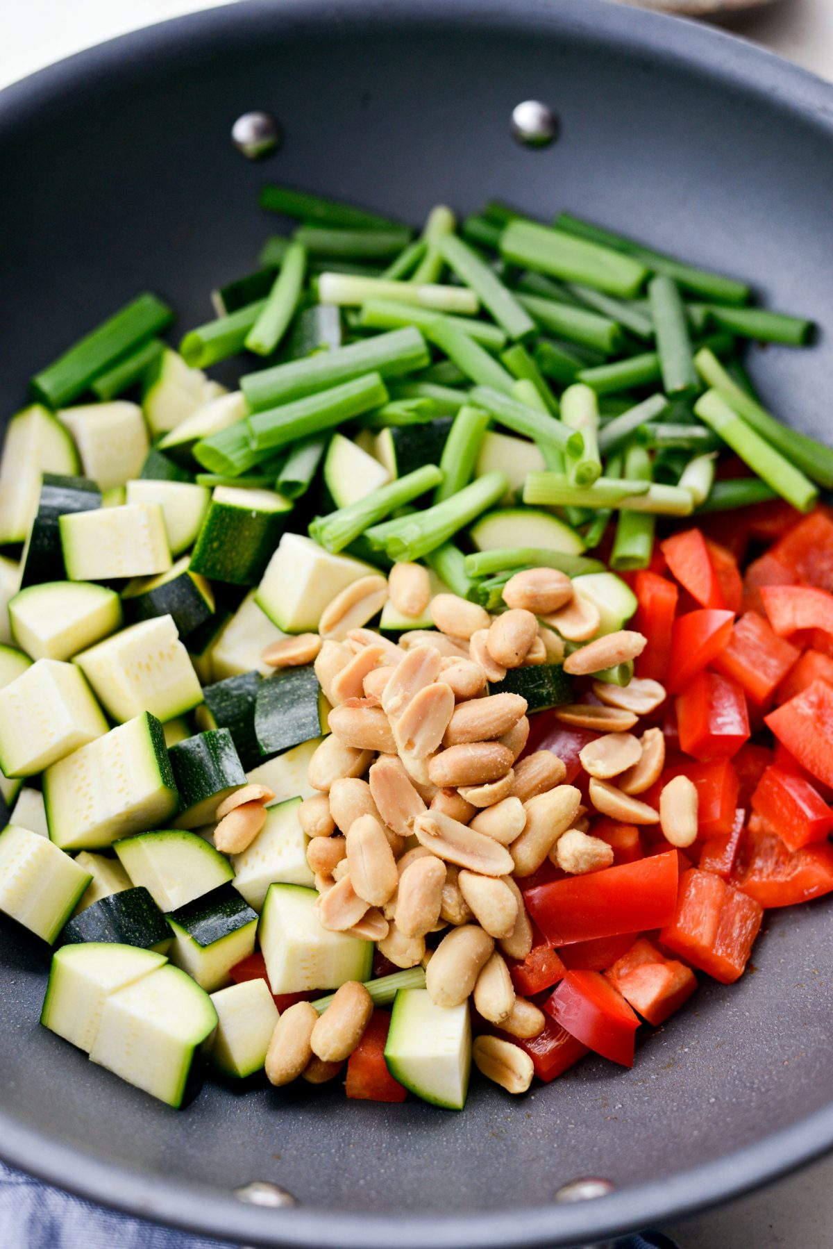 zucchini, red pepper, green onions and peanuts added to the wok