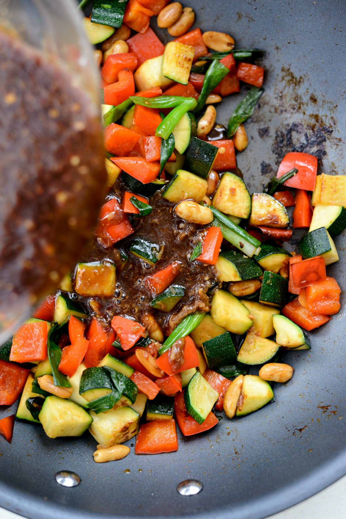 kung pao sauce added to wok with vegetables