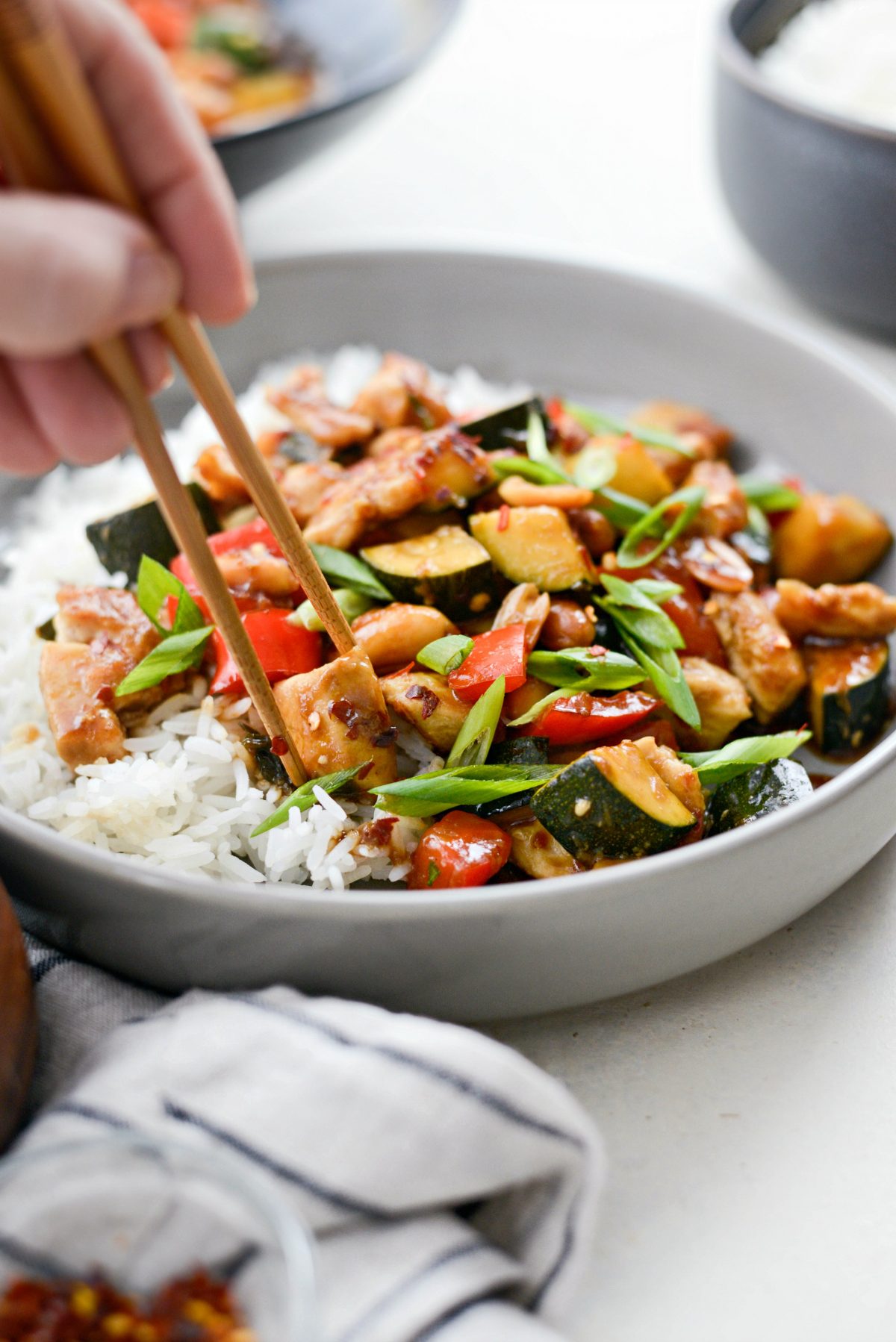 picking up a piece of Kung Pao Chicken with chopsticks