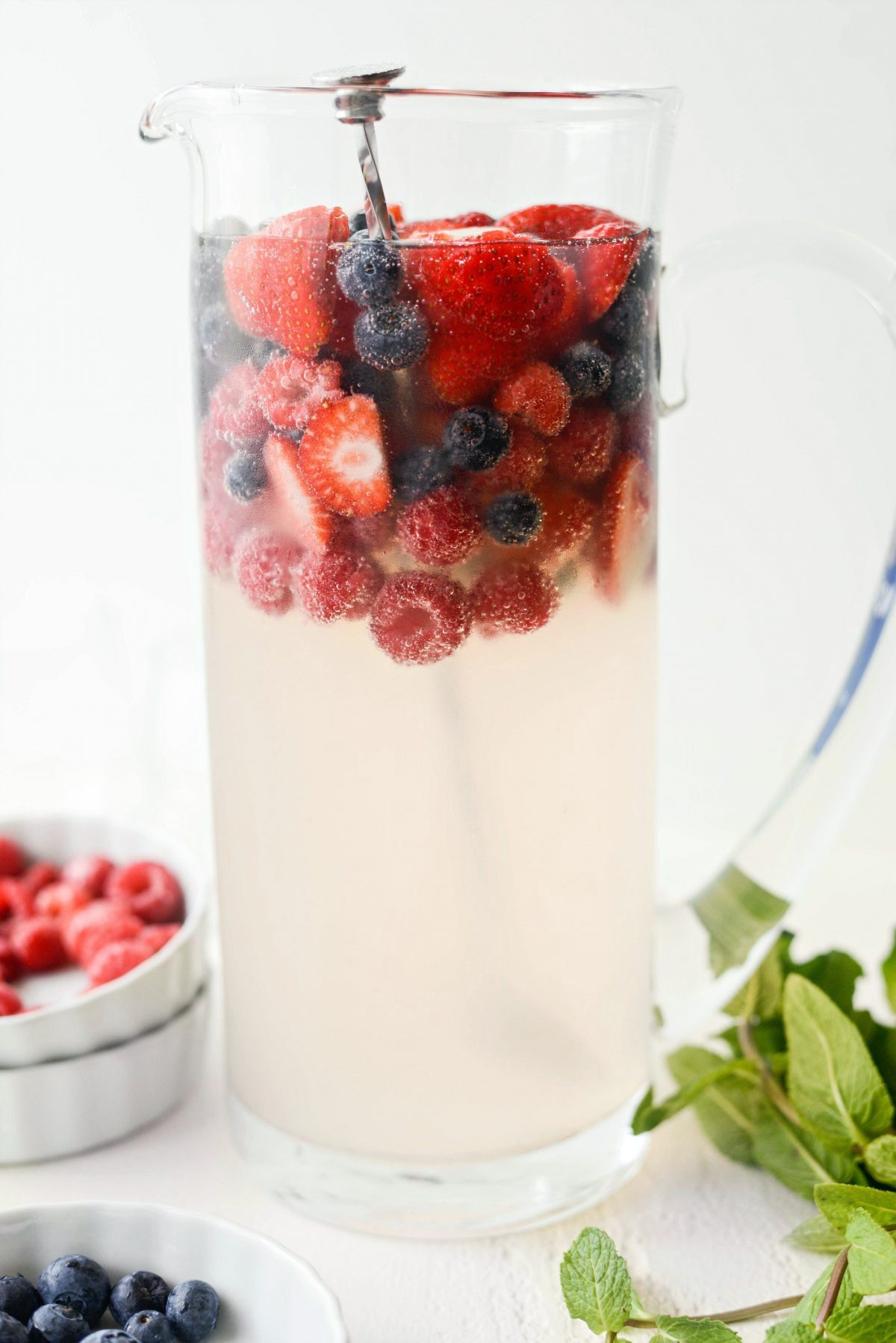 berries floating to the top of the glass pitcher.