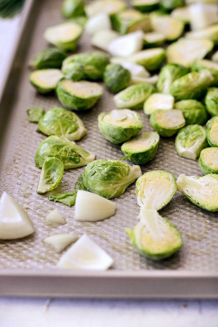 add brussels and onion to rimmed baking sheet