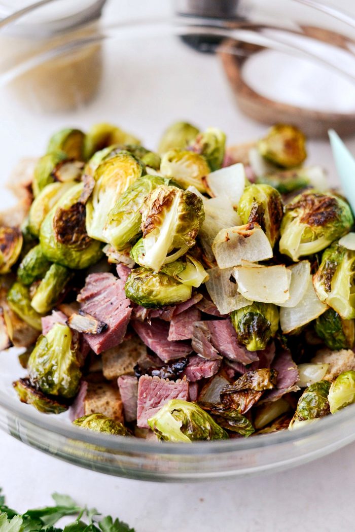 add brussels, onions and corned beef to bowl with toasted rye