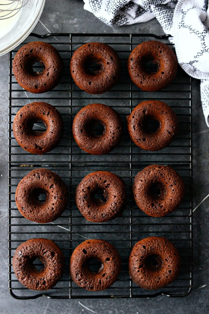 chocolate cake doughnuts inverted onto cooling rack.