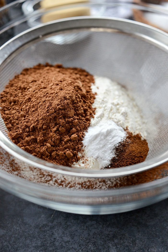 flour, cocoa powder, baking soda and instant espresso in a sieve set over a bowl.