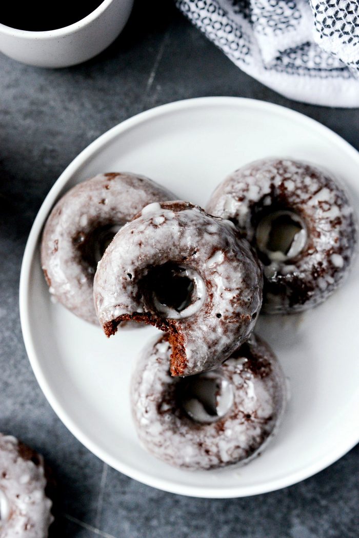 Glazed Chocolate Cake Doughnuts - close up top down shot of doughnut with a bite missing.