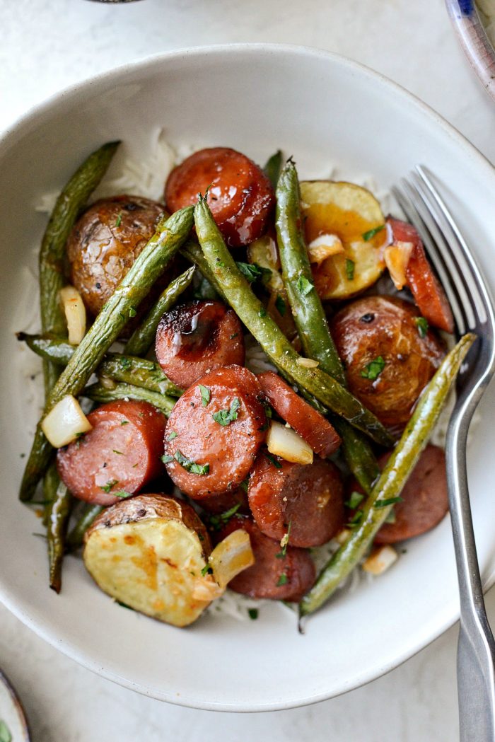 Honey Barbecue Sausage Sheet Pan Dinner - close up photo of saucy sausage, green beans and potatoes.