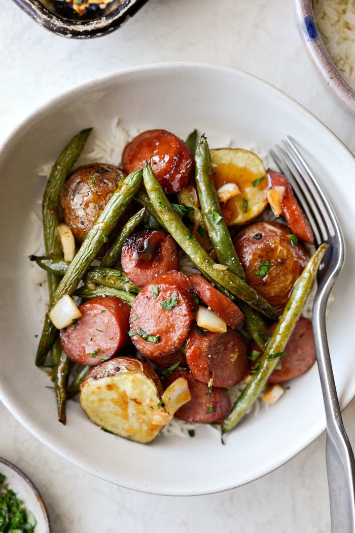 Honey Barbecue Sausage Sheet Pan Dinner - close up bowl of sausage, potatoes and green beans with fork