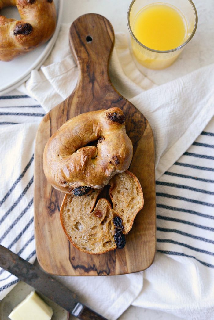 air fryer cinnamon raisin bagel on wood cutting board for serving.