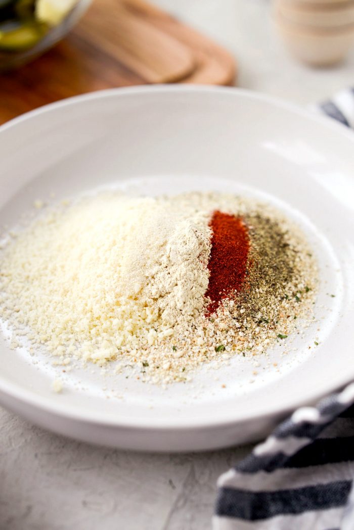 shallow bowl of italian breadcrumbs, parmesan cheese, paprika, kosher salt and black pepper, garlic and onion powder.