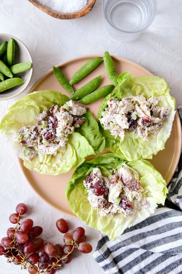 Pink plate with Greek yogurt chicken salad filled lettuce wraps.