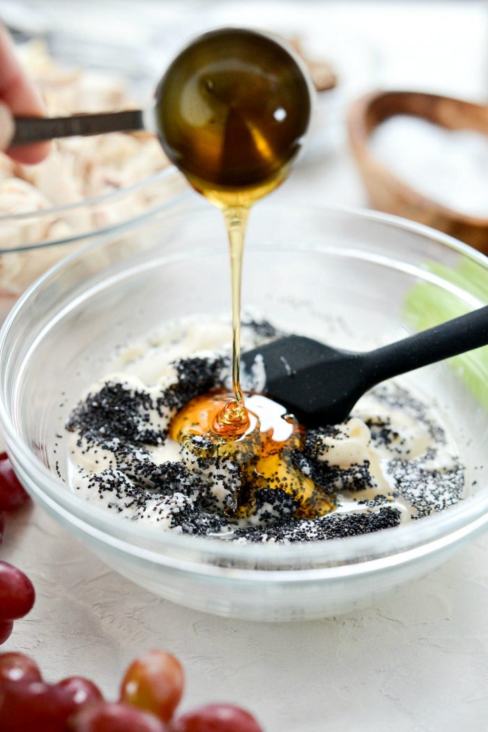 Pouring honey into bowl of remaining salad dressing ingredients.