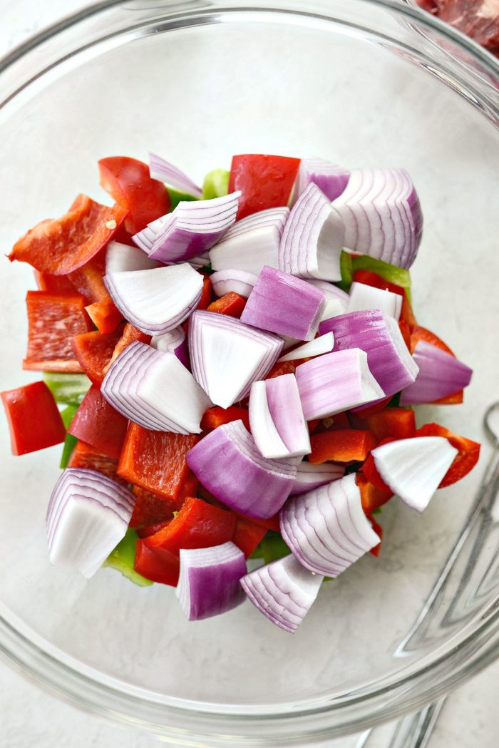 large chopped peppers and onions in glass bowl.