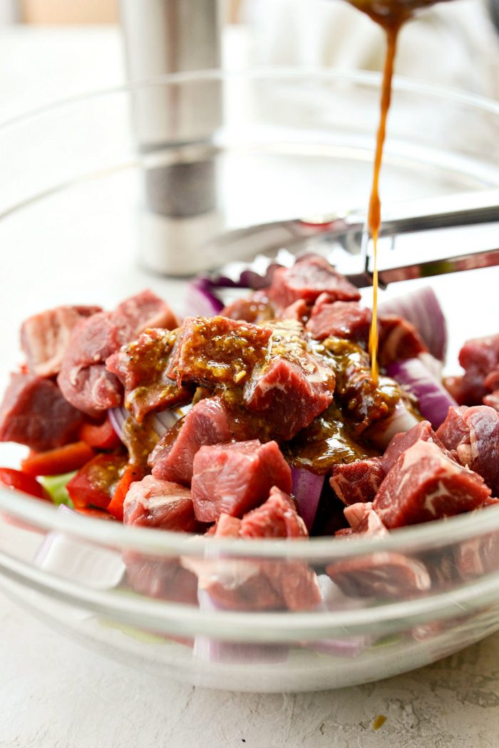 large chopped peppers and onions with steak in glass bowl.