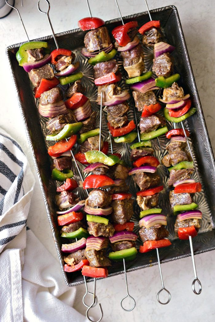 steak, peppers and onions threaded onto metal skewers.