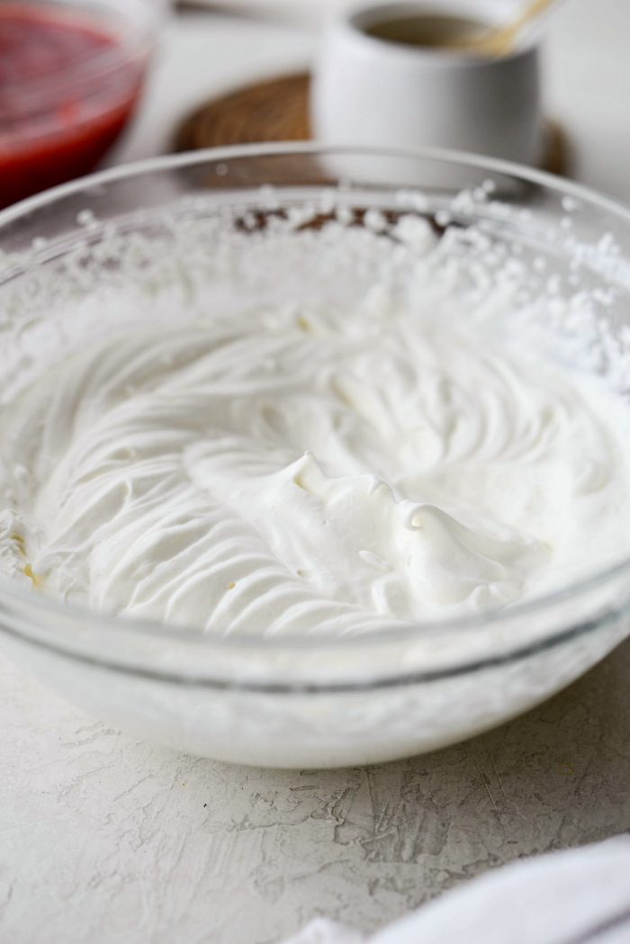 clear mixing bowl with unsweetened whipped cream.