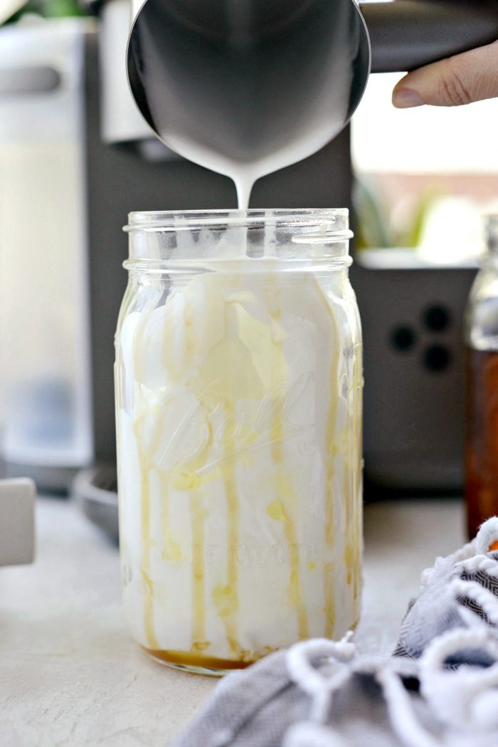 Pour frothed milk into glass jar.