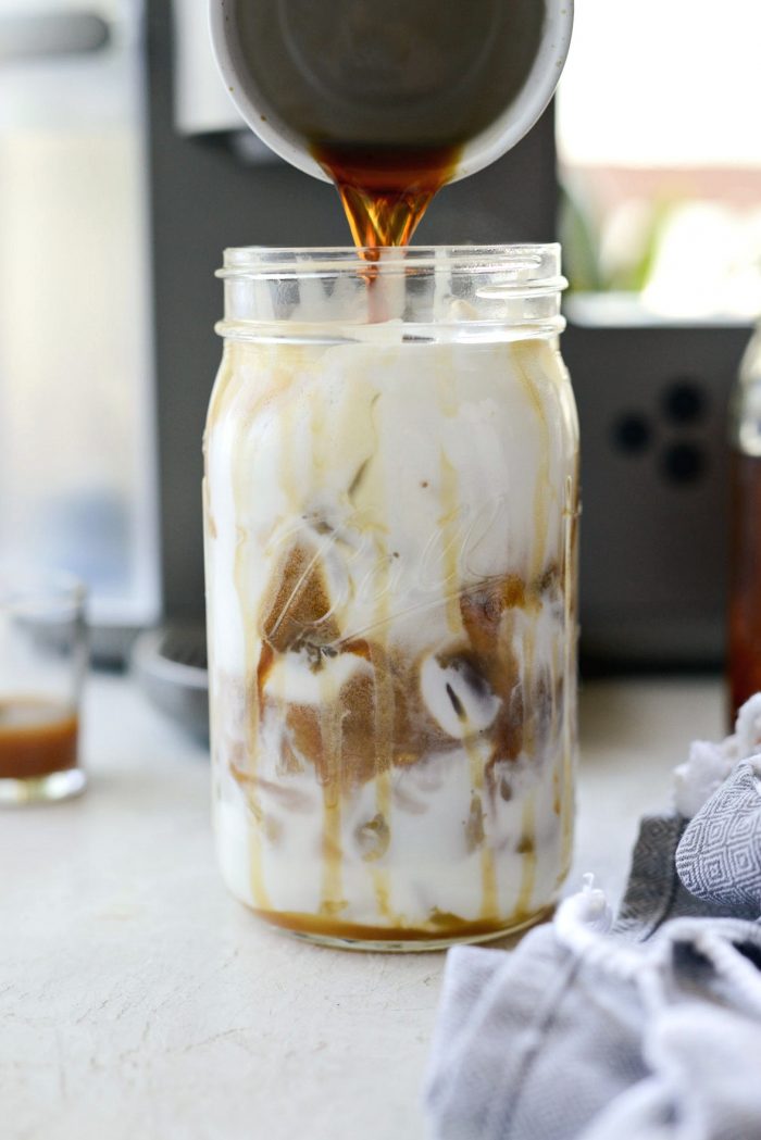 Pour sweetened espresso over frothed milk in jar.