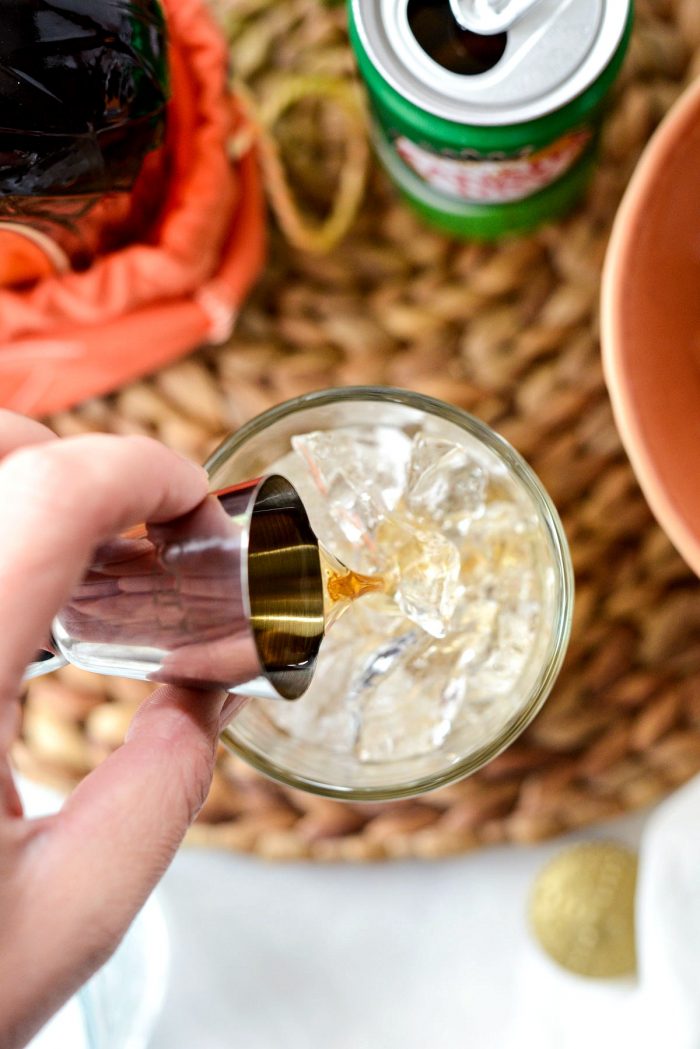 Pouring 1 shot whiskey over ice.