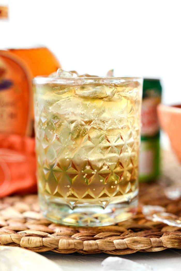 clear textured glass filled with lewis' ginger peach whiskey cocktail.