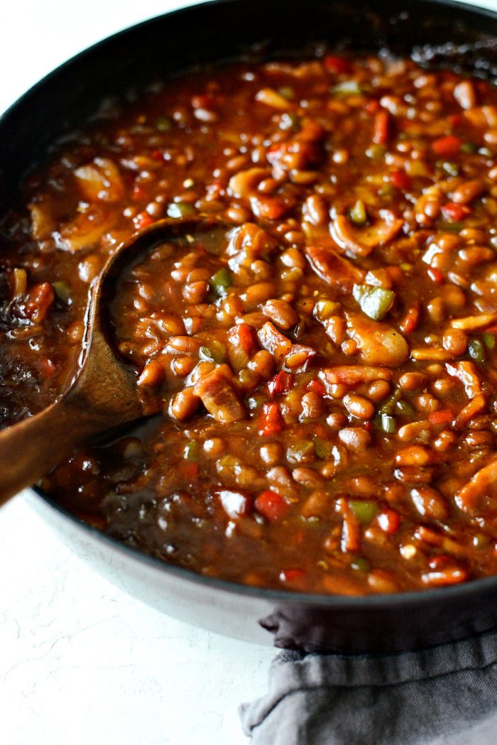 side shot of wooden spoonful of one pot wicked baked beans