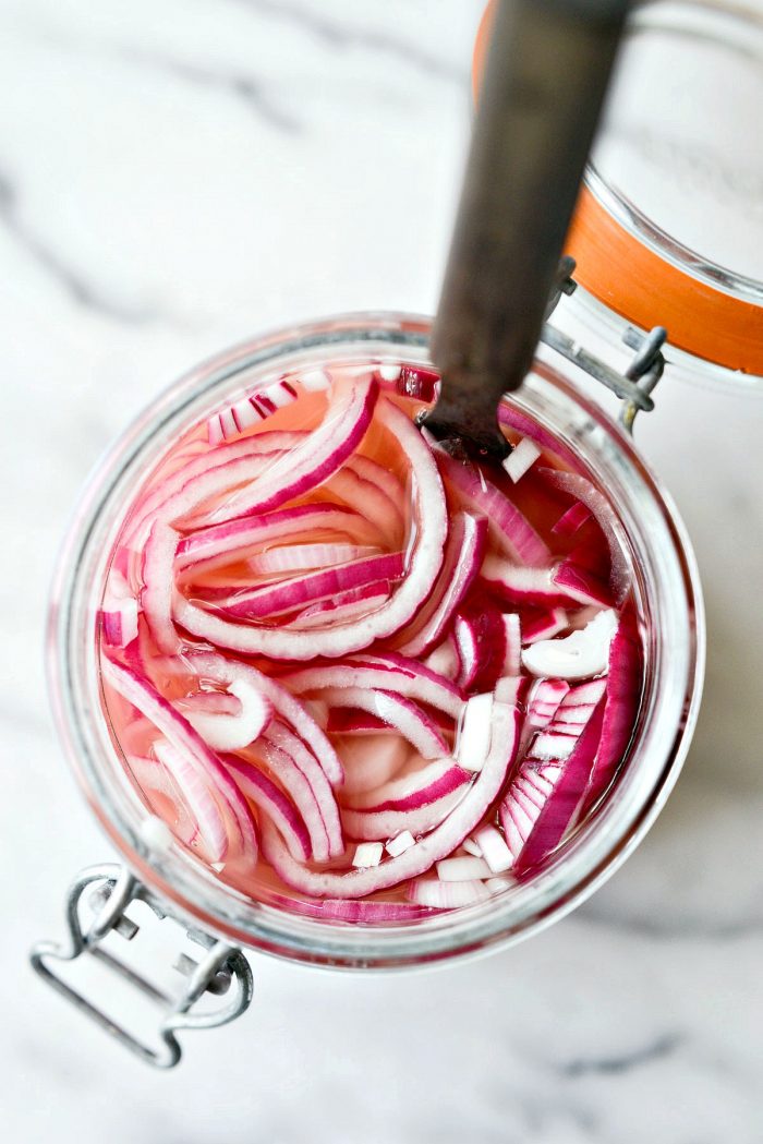 looking down into glass jar of quick pickled red onions.