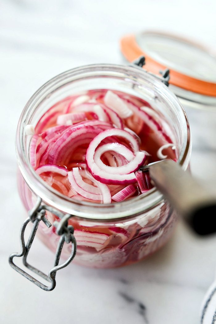 quick pickled red onions in glass jar with fork.