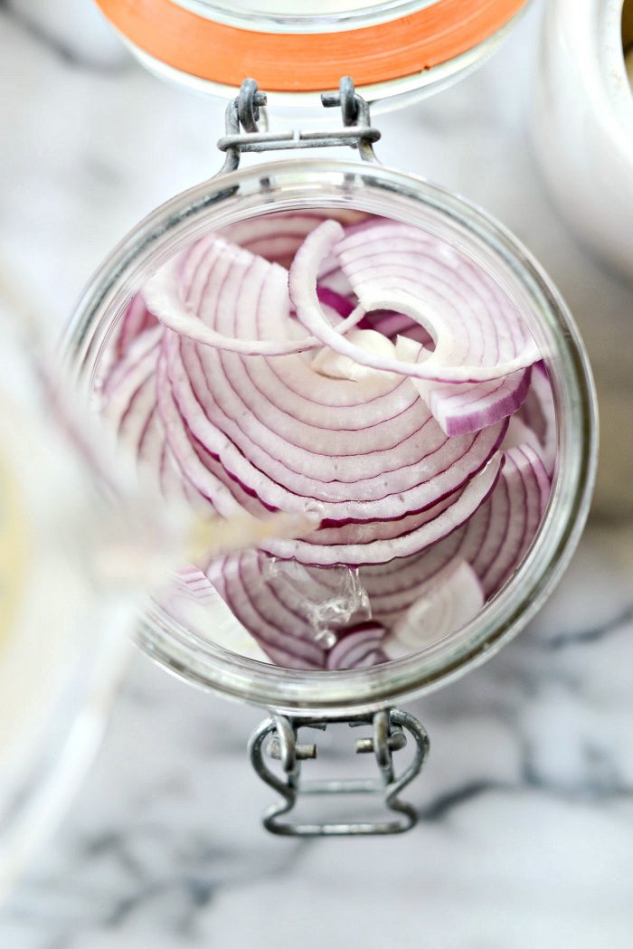 pour vinegar liquids over top of onions in jar.