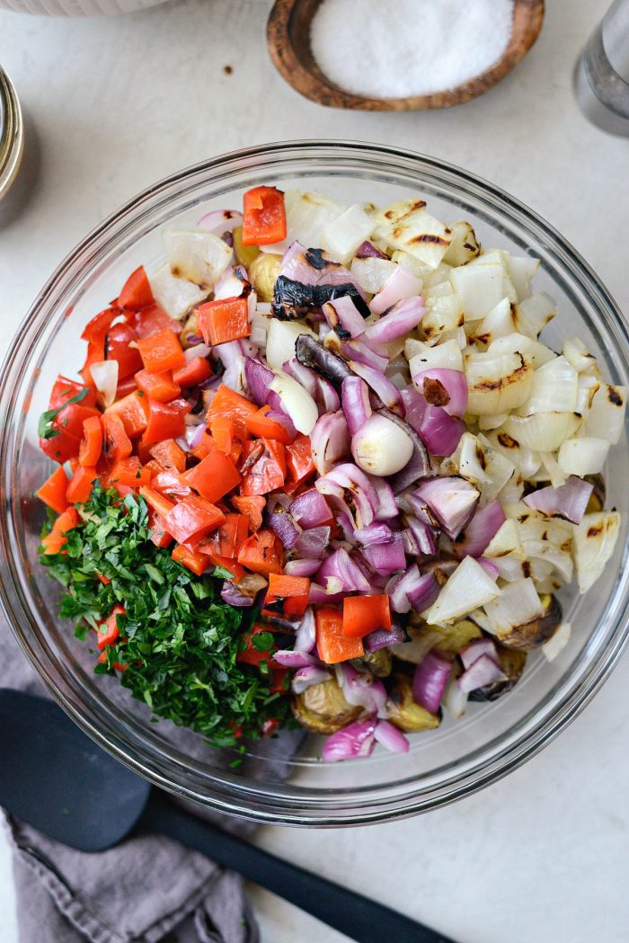 grilled potatoes, pepper, onions and chopped parsley in glass bowl.