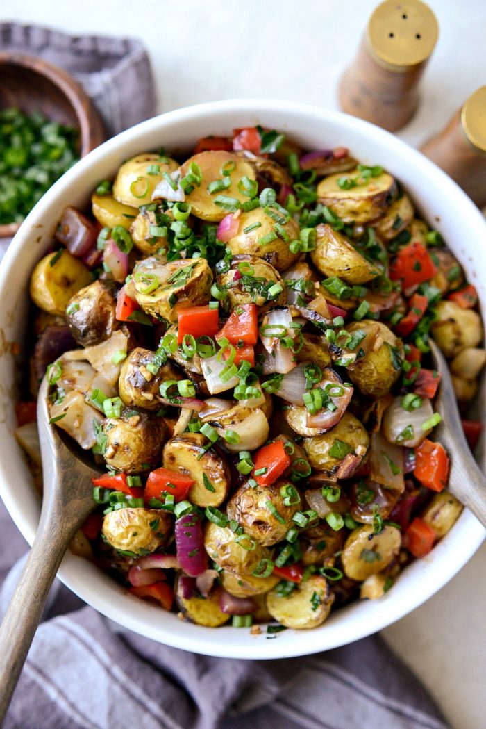 Tuck's potato salad in a cream bowl with grey wood serving spoons