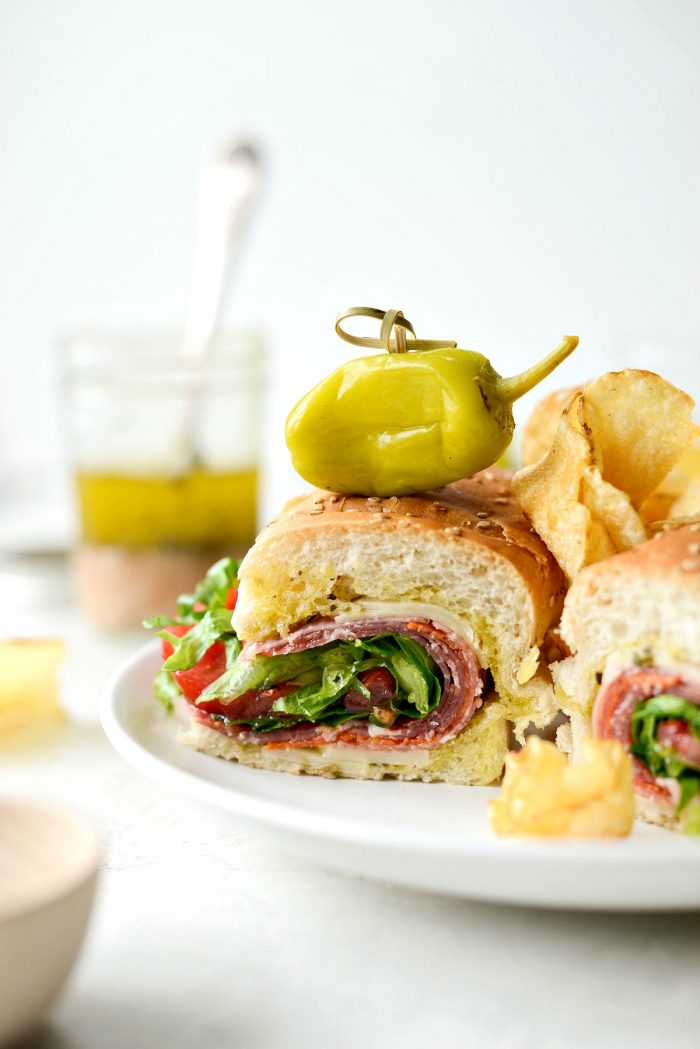 close up of italian sub sandwich with chips and peperoncini