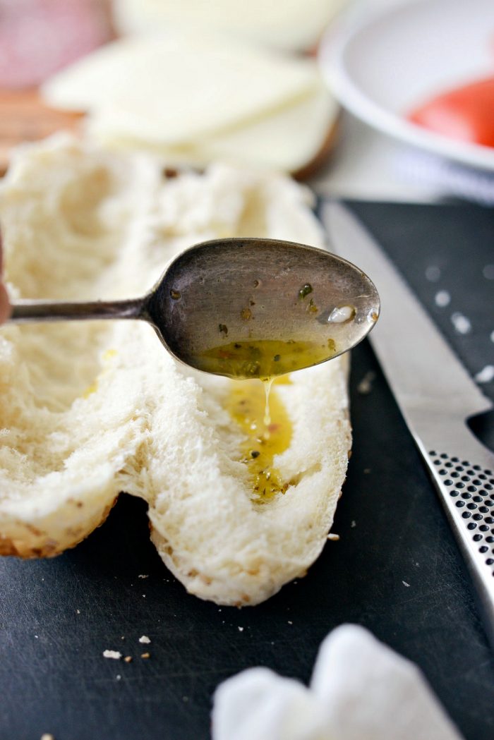 italian dressing spooned onto inside of sub bun