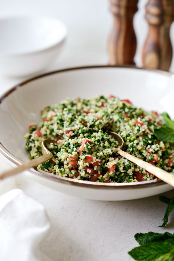 gold spoons in a bowl of homemade tabbouleh.