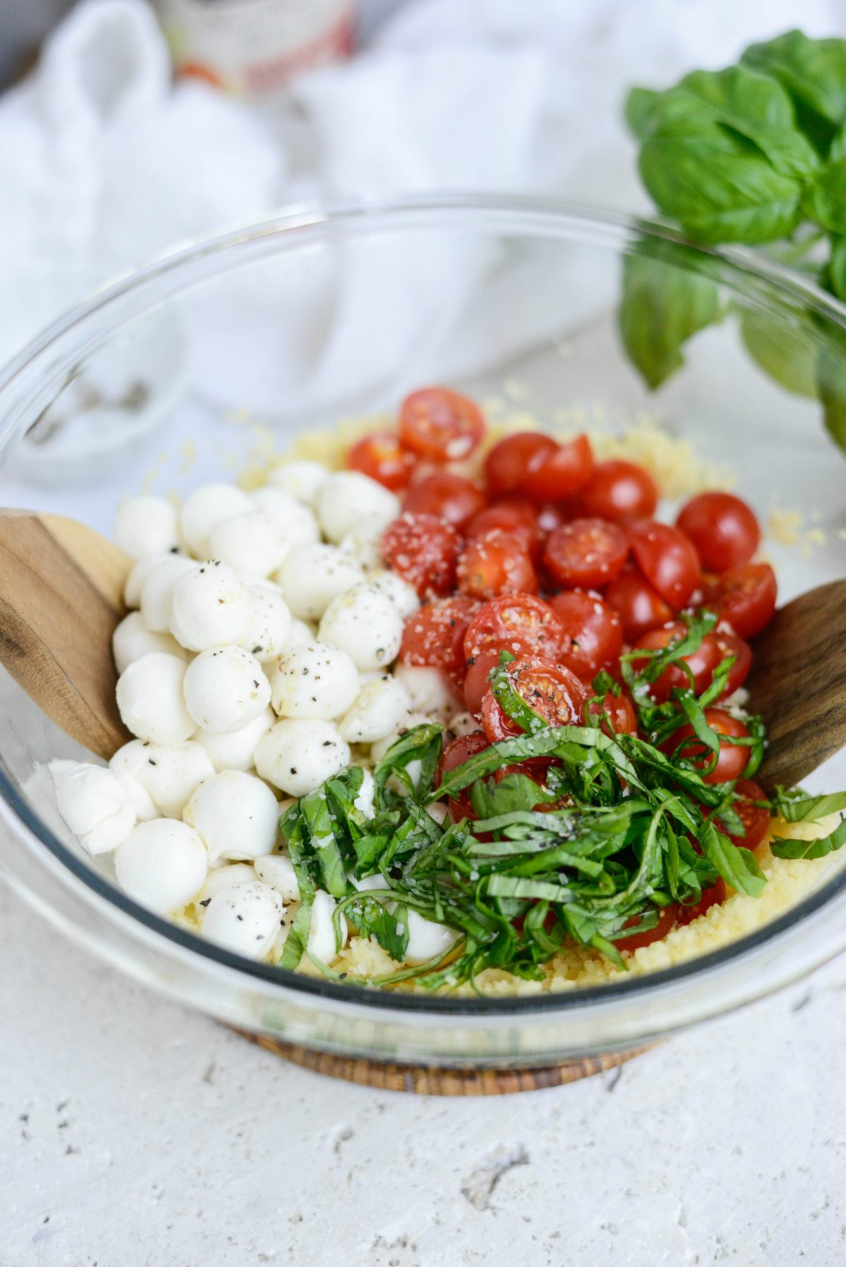 add in pearled mozzarella, cherry tomatoes, basil, salt and pepper