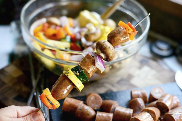 ingredients for chicken sausage vegetable kebabs skewered onto metal skewers