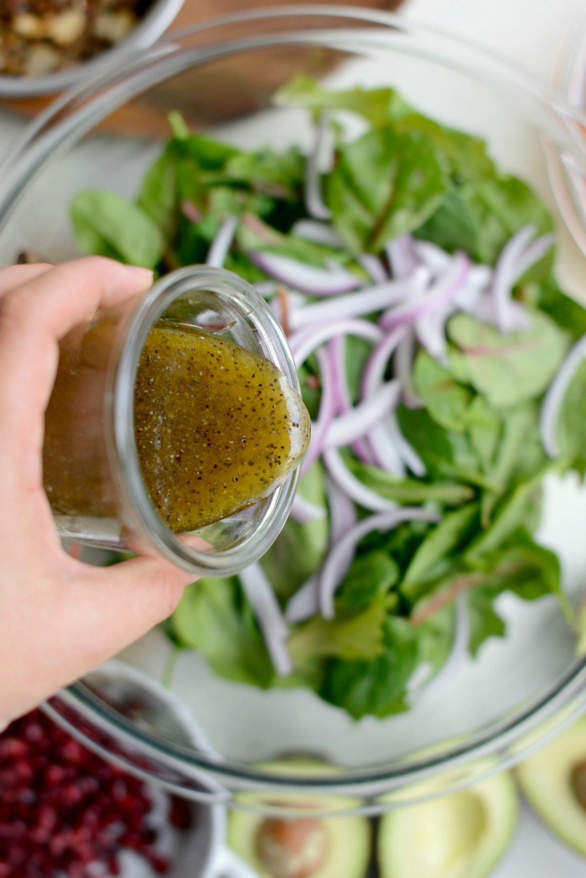 pour a little dressing over salad greens and onions