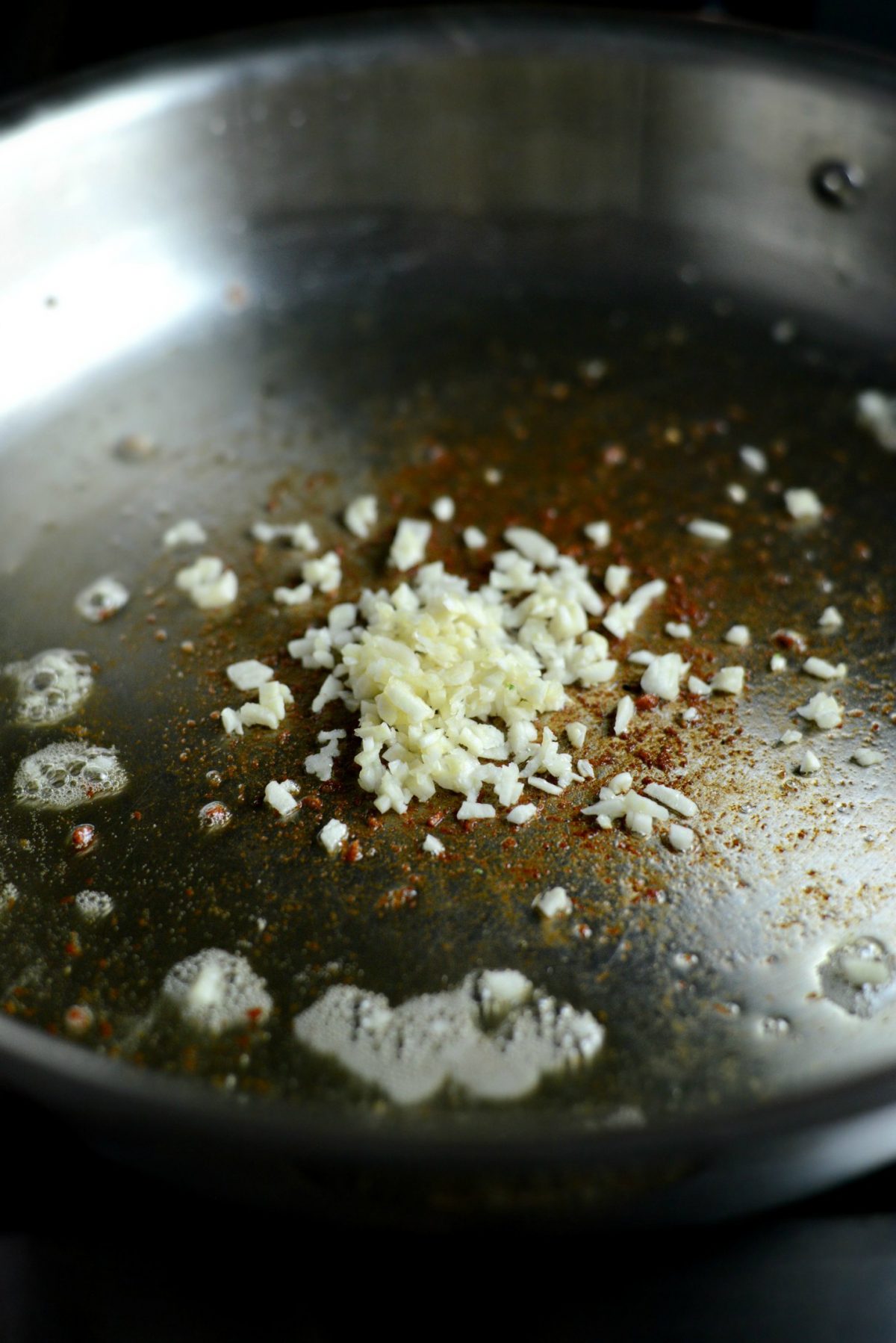 Remove pancetta and add minced garlic to the fat in the skillet.