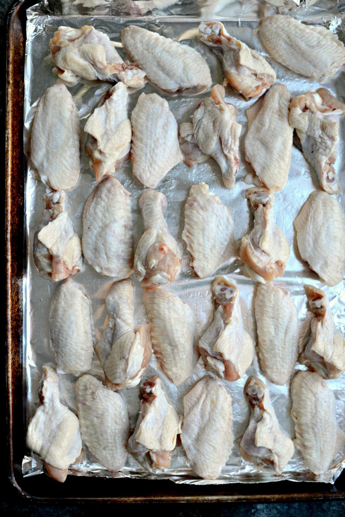 wings and drumettes on foil lined, rimmed baking sheet.