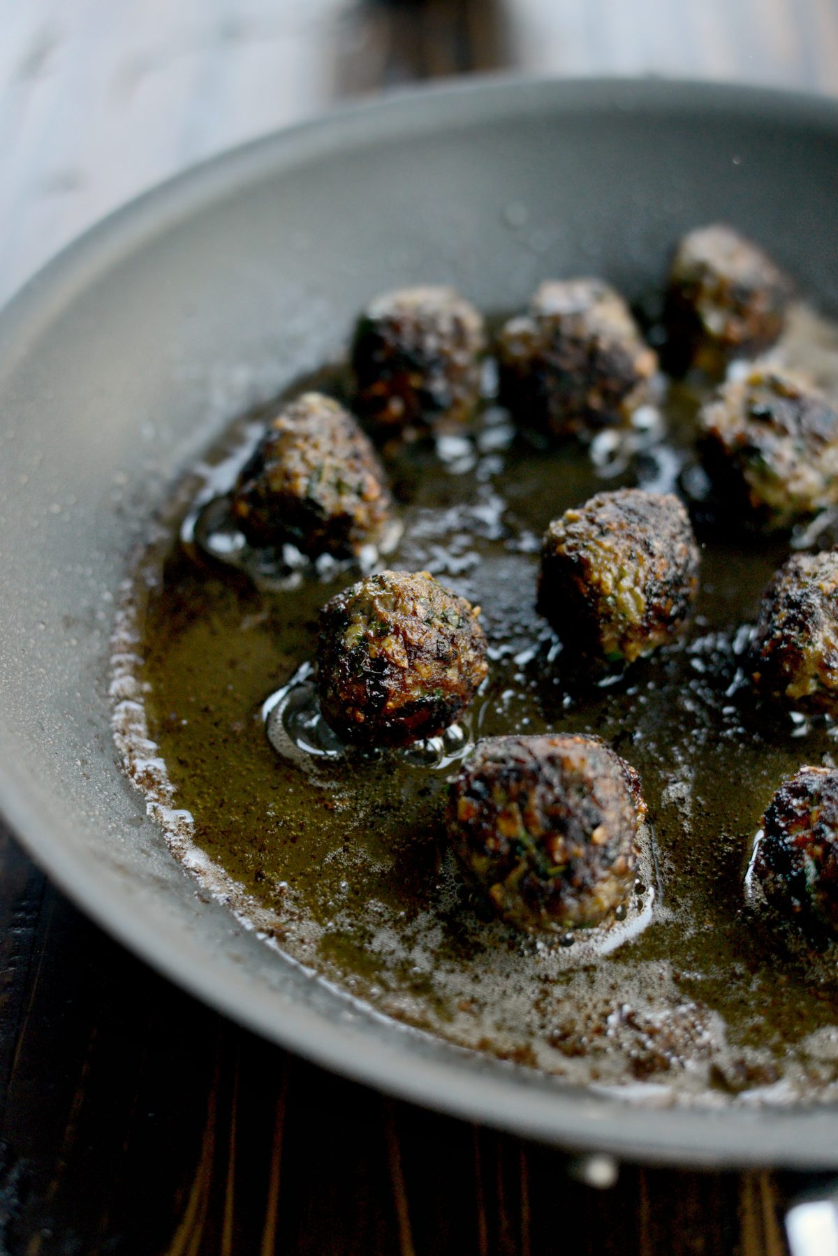 brown meatballs in skillet.