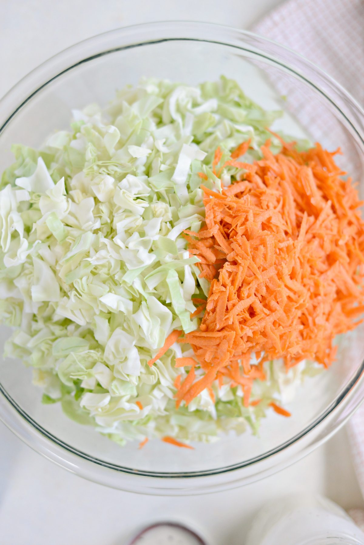 shredded cabbage and carrots in a large mixing bowl.