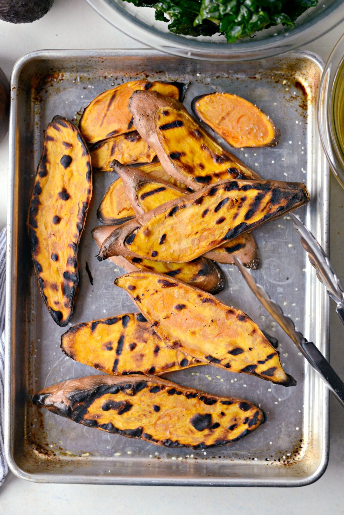 grilled sweet potatoes on a rimmed baking sheet.