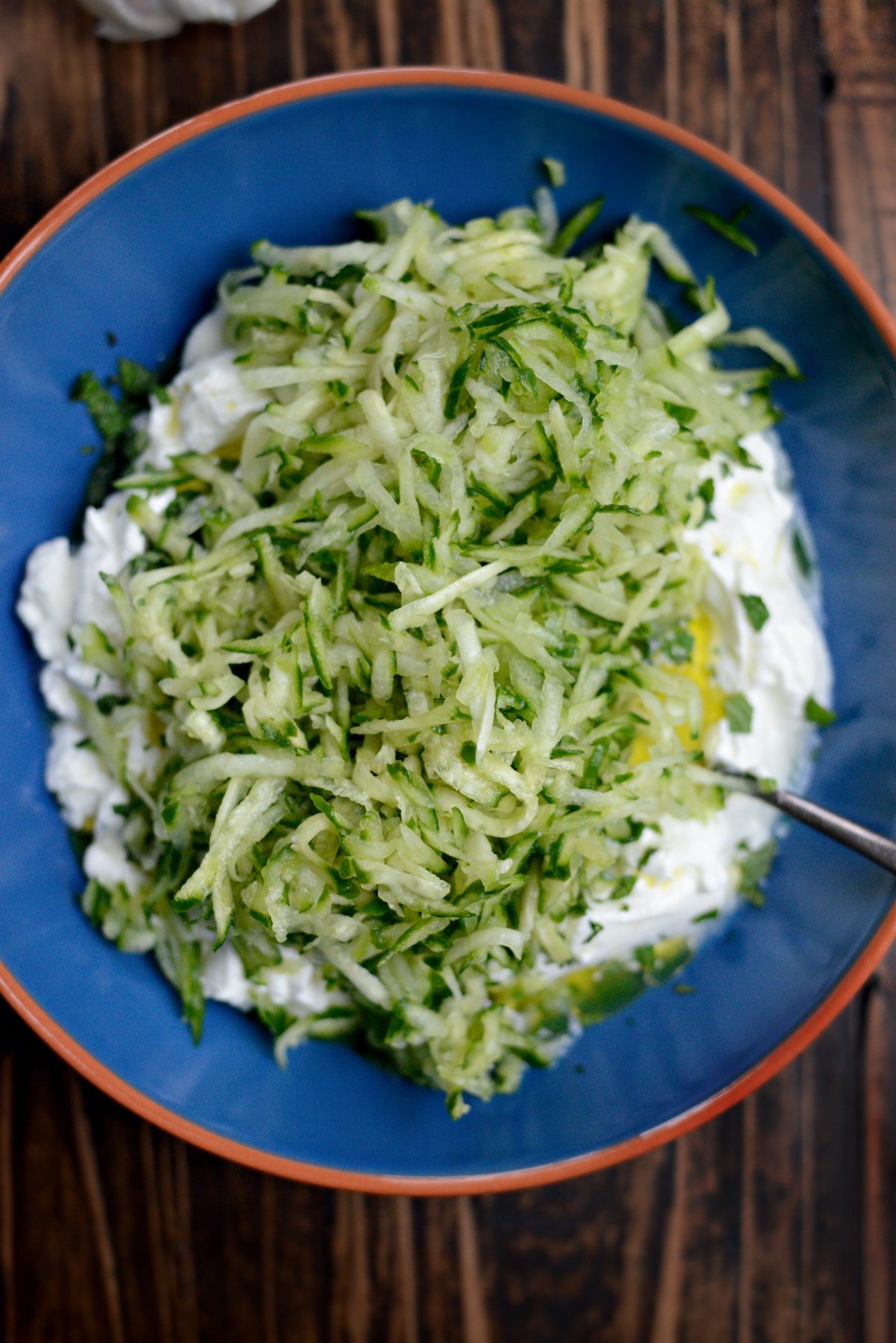 Add grated fresh garlic and shredded and drained cucumber